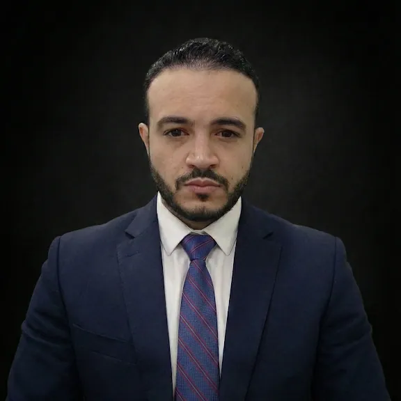 Portrait of Jerick Castro Ortiz in a navy suit and striped tie